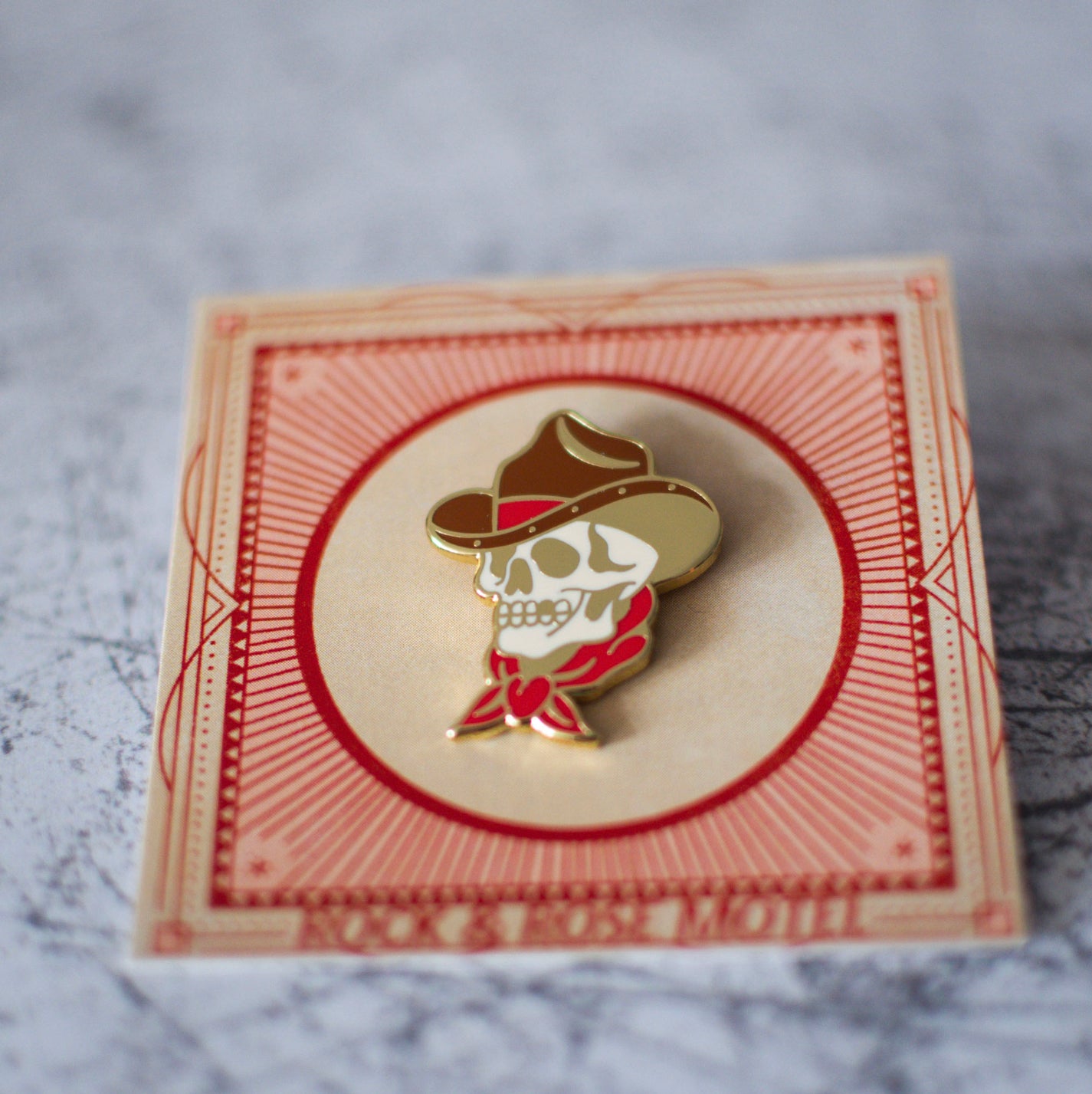 American Traditional Cowboy Skull Enamel Pin In Packaging Angled View