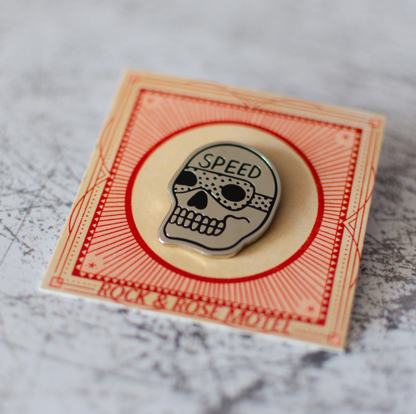 American Traditional Speed Skull Design Enamel Pin in Packaging Close Up