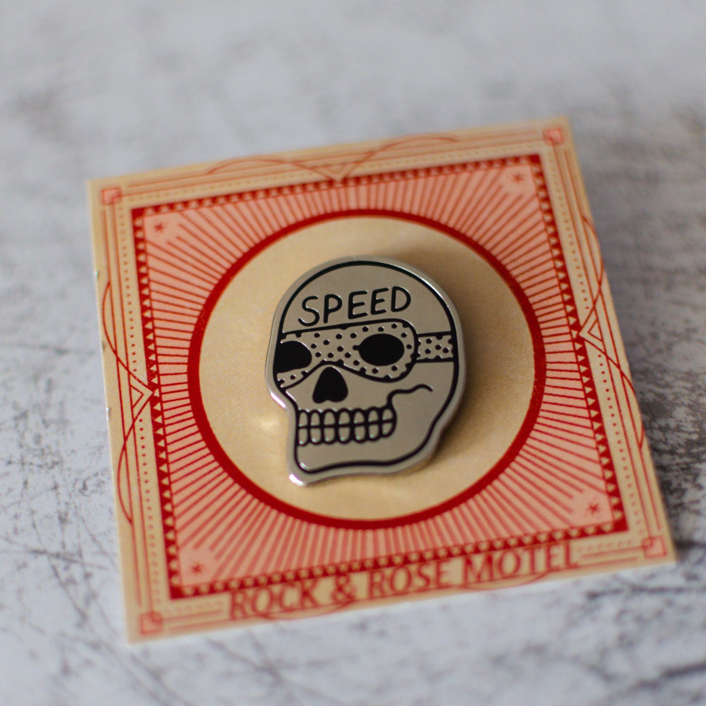 American Traditional Speed Skull Design Enamel Pin in Packaging Full View