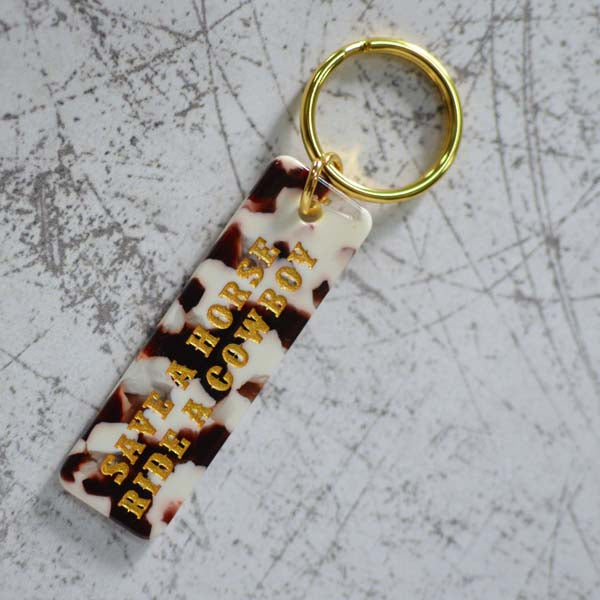Save A Horse Ride A Cowboy Cow Print Keychain Angled View
